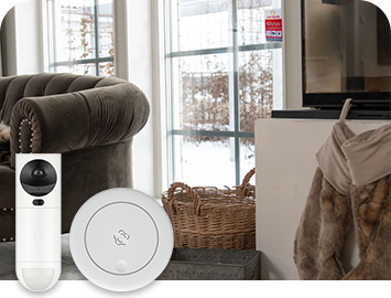 Nojatuoli ja takka. Etualalla Verisuren GuardVision-videokamerailmaisin ja optinen sarjaankytkettävä palovaroitin.