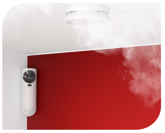 GuardVision-videokamera ilmaisin huoneen nurkassa. Katossa palovaroitin, joka on havainnut savua.