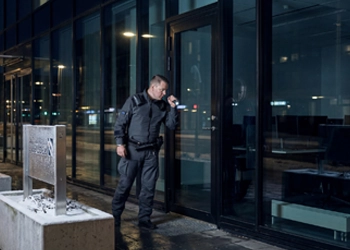 Vartija tarkastaa myyntiliikkeen ikkunan kunnon .