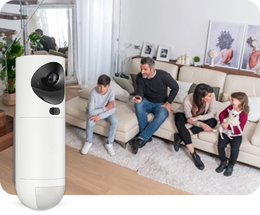 Taustalla perhe istuu sohvalla, etualalla Verisuren valvontakamera.