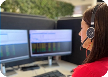 Hälytyskeskuspäivystäjä tarkastelee tietokoneen näyttöjä.