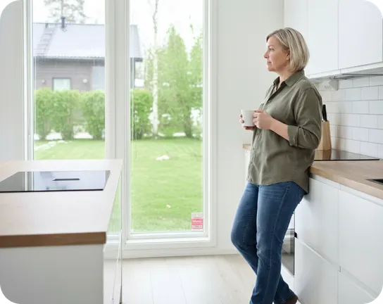 Verisuren asiakas keittiössään kahvikuppi kädessä.