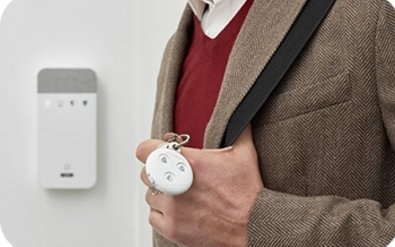 Mies kävelee näppäimistön ohi kauko-ohjain kädessään.