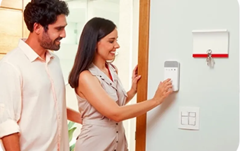 Nainen ja mies astuvat sisään ja käyttävät näppäimistöä käyttökoodilla.